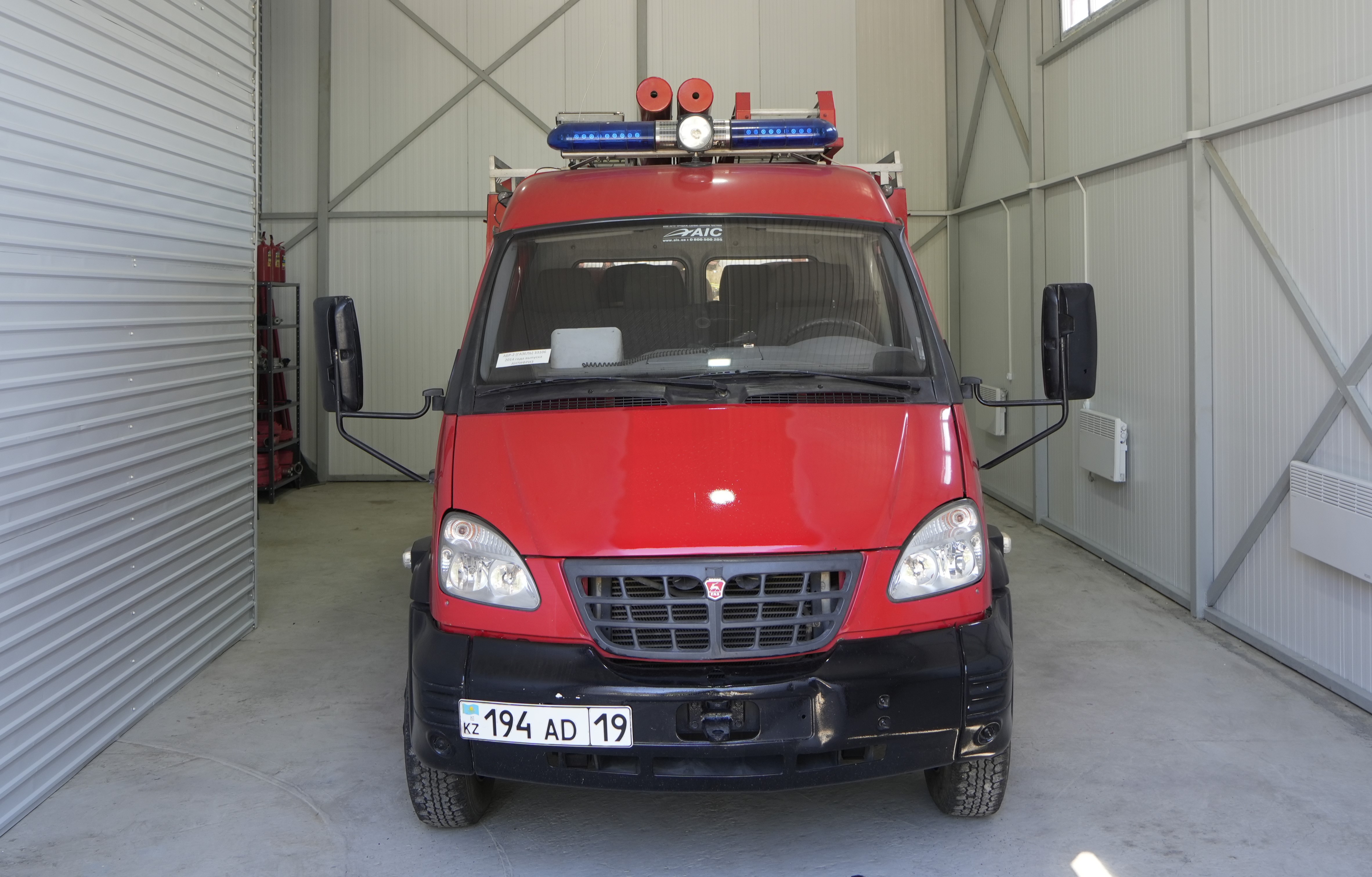 Гараждағы қызыл түсті өрт сөндіру көлігі.