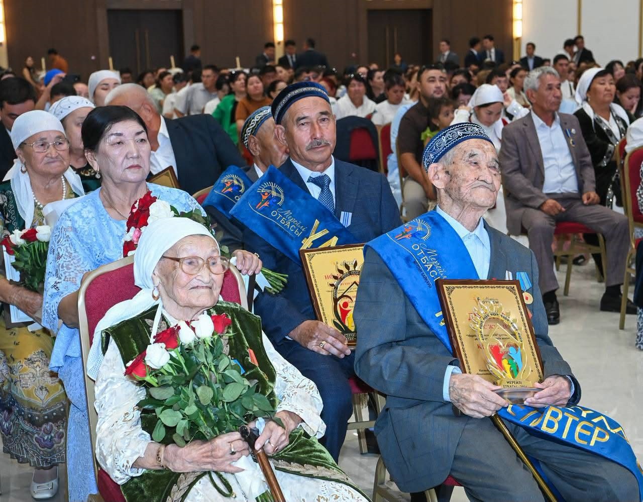 Салтанатты жиында марапат алған қарт адамдар мен қонақтар.