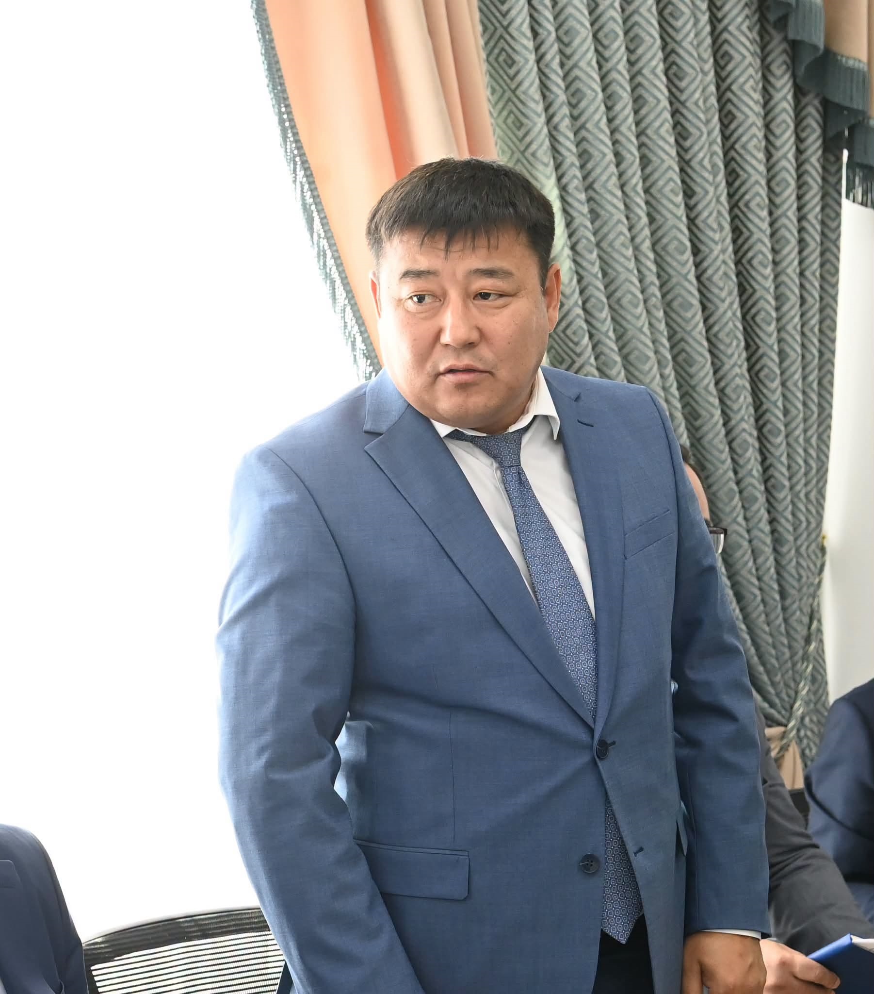Көк костюм мен галстук киген ер адамның портреті.