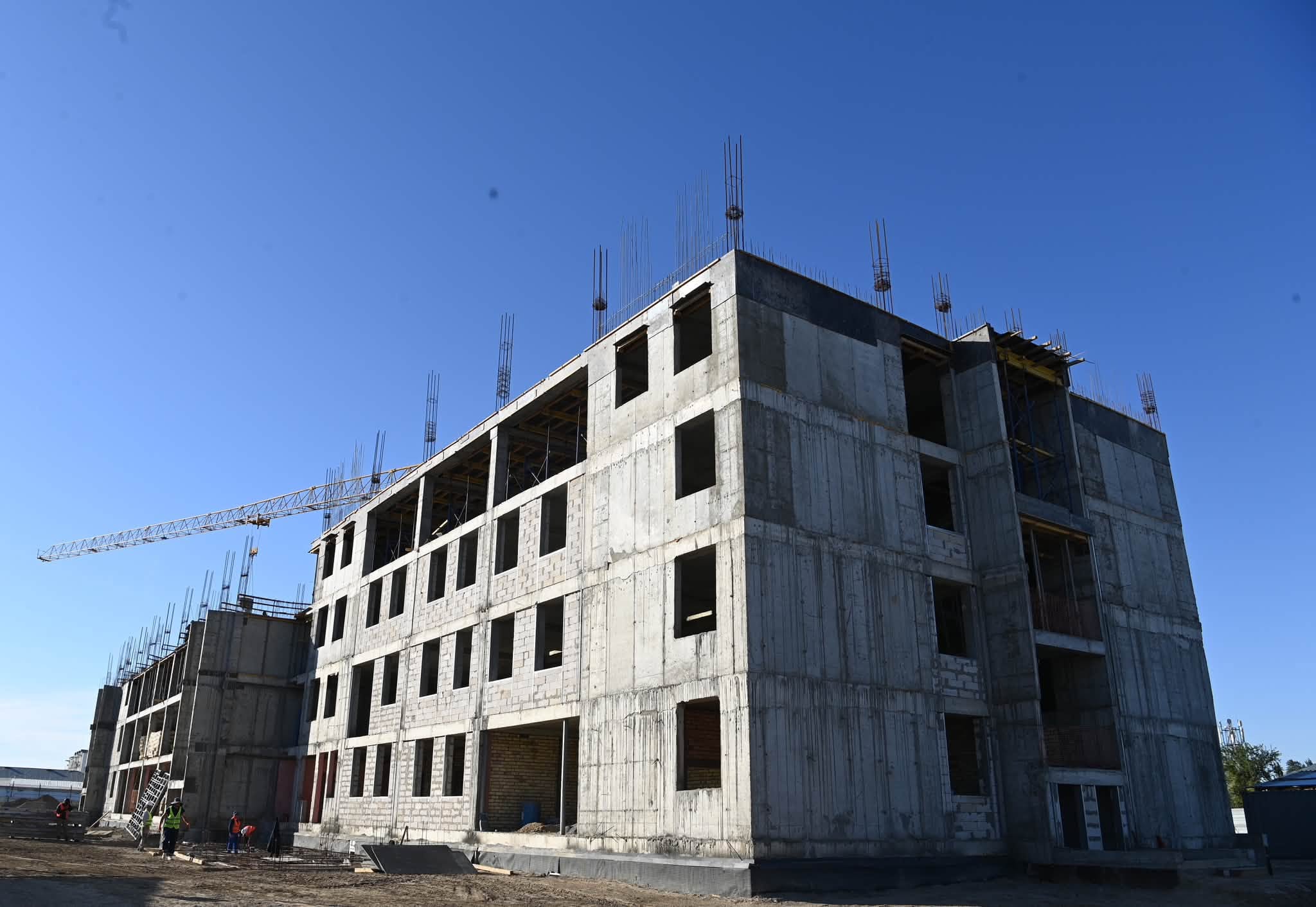 Құрылыс кезеңіндегі көпқабатты бетон ғимарат.