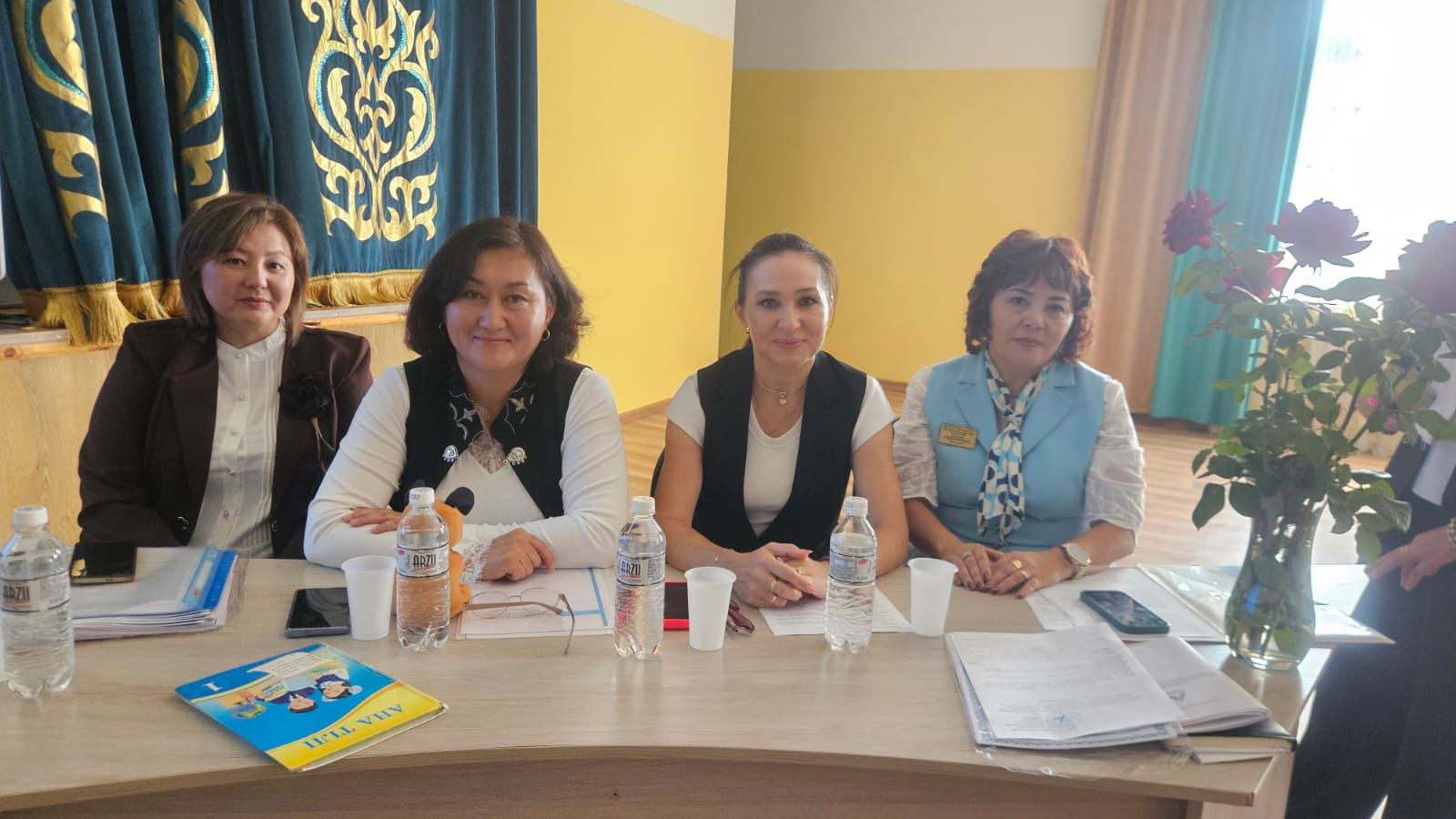 Үстел басында отырған төрт әйел.