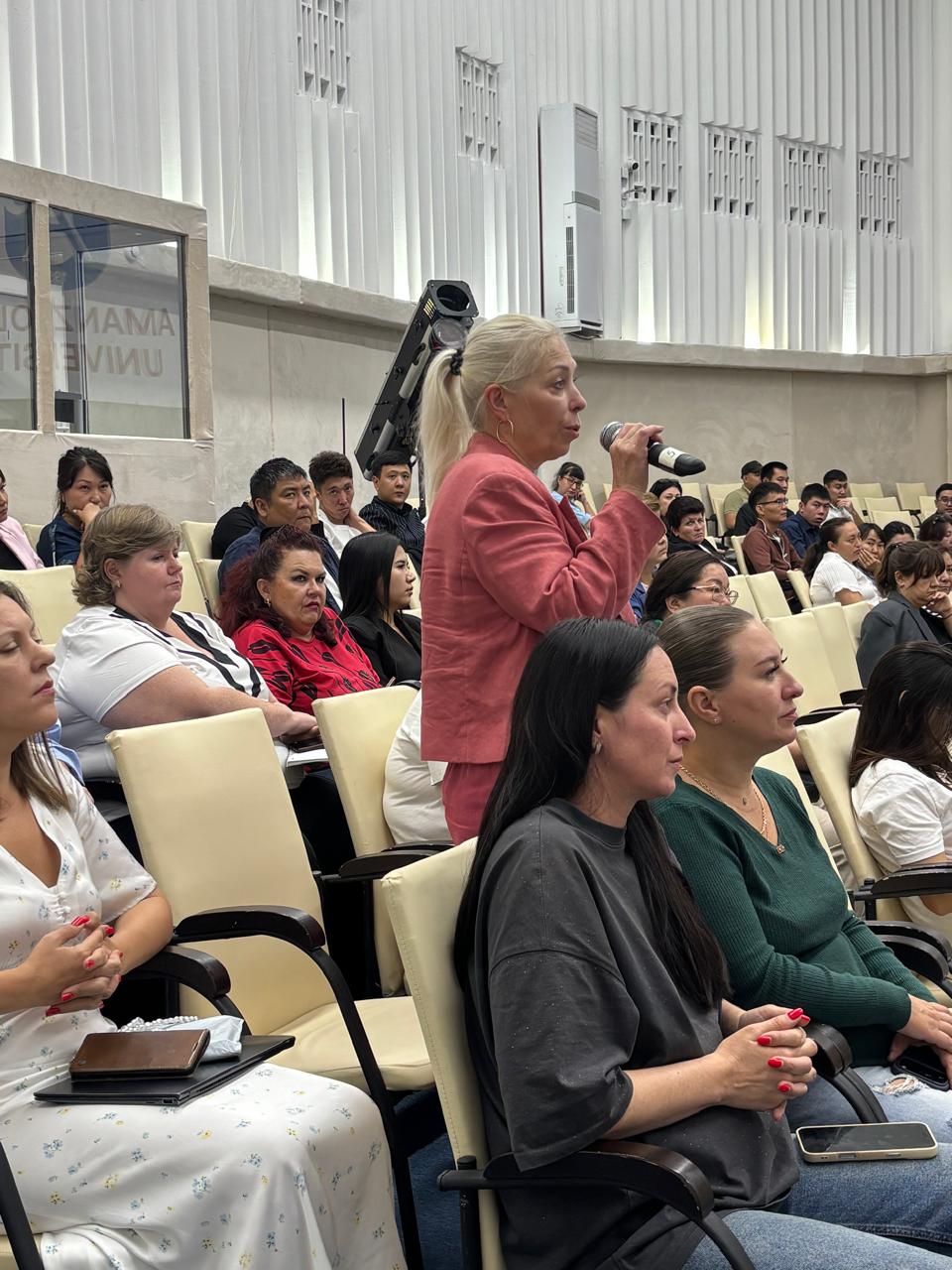 Суретте салық заңнамасының өзекті мәселелеріне арналған іскерлік семинар бейнеленген. Іс-шараның атмосферасы ресми әрі іскерлік сипатта. Қатысушылар кәсіби мәселелерді талқылап, пікір алмасуда.