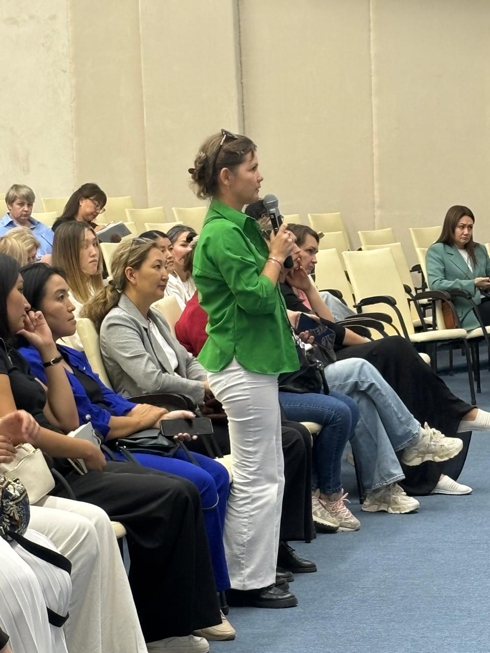 Суретте салық заңнамасының өзекті мәселелеріне арналған іскерлік семинар бейнеленген. Іс-шараның атмосферасы ресми әрі іскерлік сипатта. Қатысушылар кәсіби мәселелерді талқылап, пікір алмасуда.